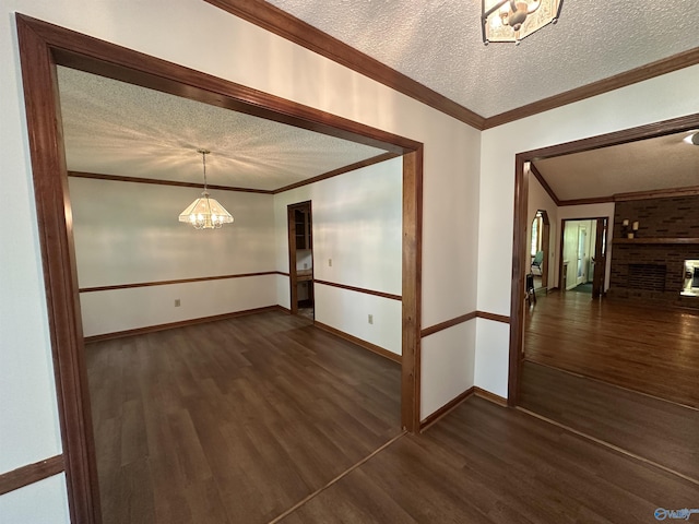 2008 Oakleaf Ln, Arab, AL 35016 - empty room with dark wood-style flooring, a notable chandelier, a textured ceiling, baseboards, and ornamental molding