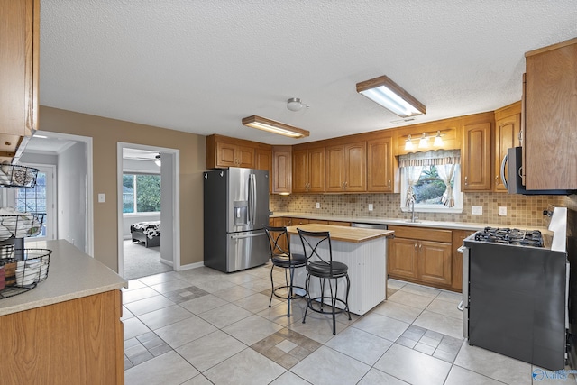 kitchen with stainless steel appliances, a center island, backsplash, and a kitchen bar