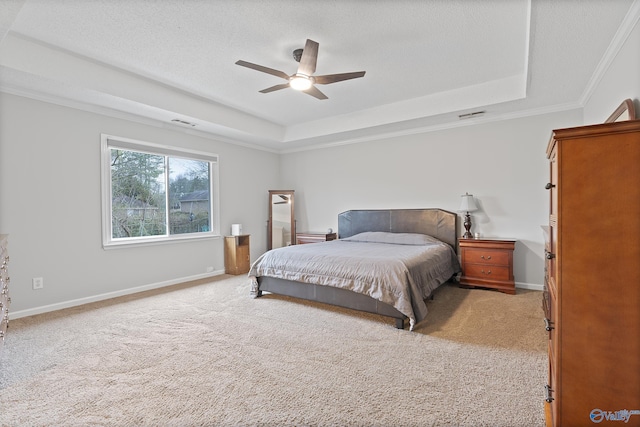 carpeted bedroom featuring crown molding, ceiling fan, a tray ceiling, and a textured ceiling