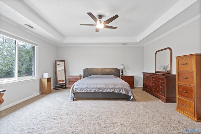 carpeted bedroom with ceiling fan and a raised ceiling