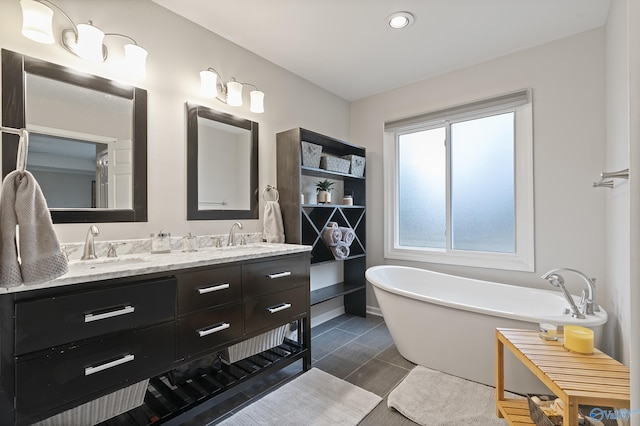 bathroom with tile patterned floors, vanity, and a bathing tub