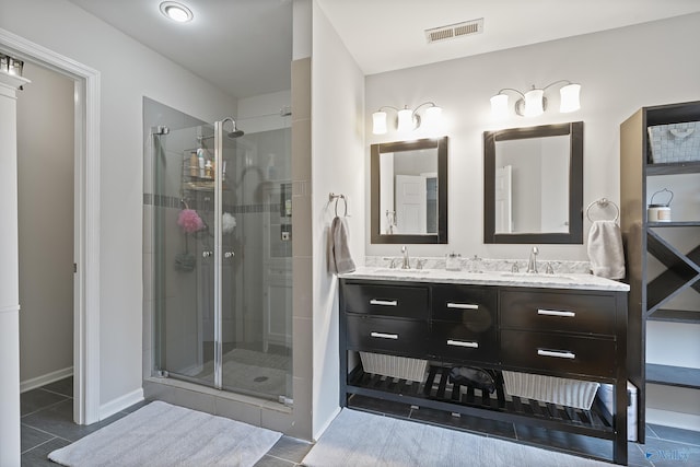 bathroom featuring vanity, a shower with shower door, and tile patterned flooring