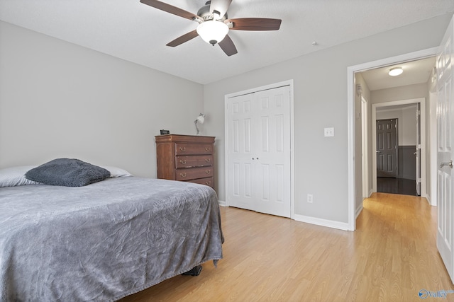 bedroom featuring ceiling fan, a closet, and light wood-type flooring