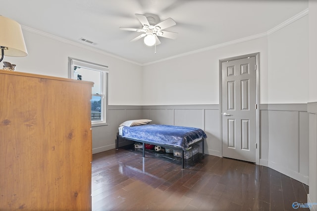 bedroom with crown molding, ceiling fan, and dark hardwood / wood-style flooring