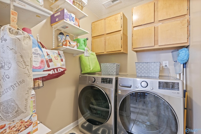 laundry room with washing machine and dryer and cabinets