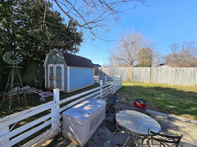 view of yard featuring a storage unit, an outbuilding, a fenced backyard, and a patio area