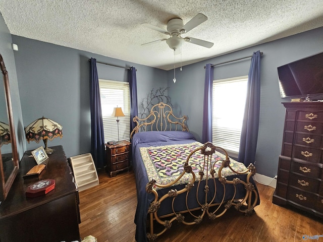 bedroom featuring baseboards, wood-type flooring, a textured ceiling, and a ceiling fan