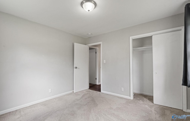 unfurnished bedroom featuring a closet and light colored carpet