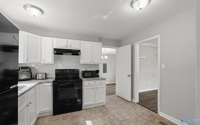 kitchen featuring white cabinets, decorative backsplash, light wood-type flooring, and black appliances