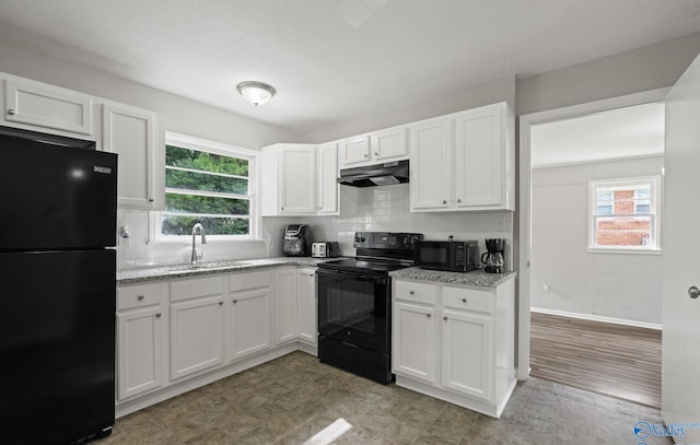 kitchen with black appliances, sink, light stone countertops, tasteful backsplash, and white cabinetry