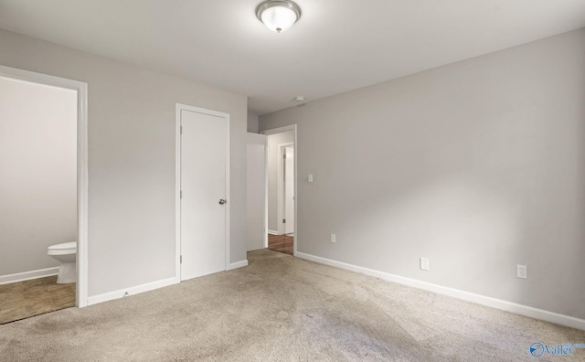 unfurnished bedroom featuring carpet, connected bathroom, and a closet