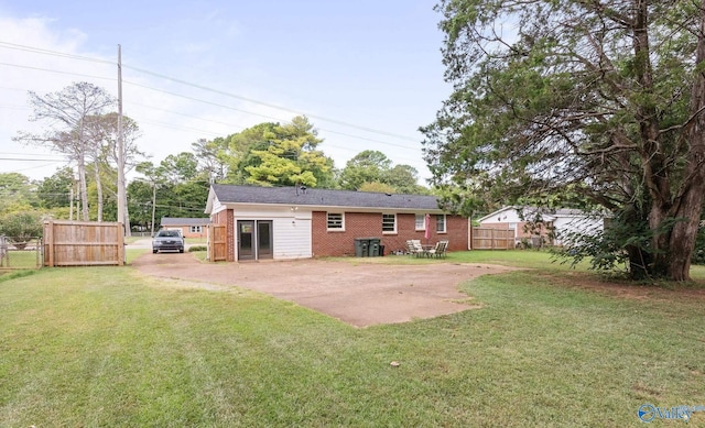 rear view of property with a yard and a patio area