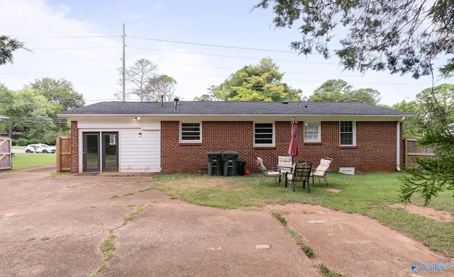 rear view of property featuring a lawn and a patio area