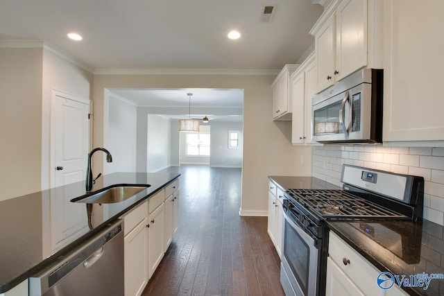 kitchen with a sink, tasteful backsplash, dark wood finished floors, appliances with stainless steel finishes, and ornamental molding