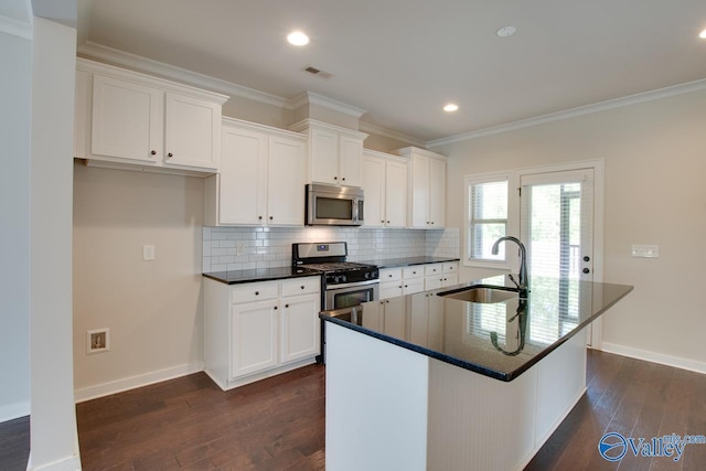 kitchen with appliances with stainless steel finishes, dark wood-type flooring, white cabinetry, and a sink
