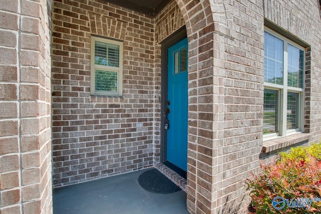 doorway to property with brick siding