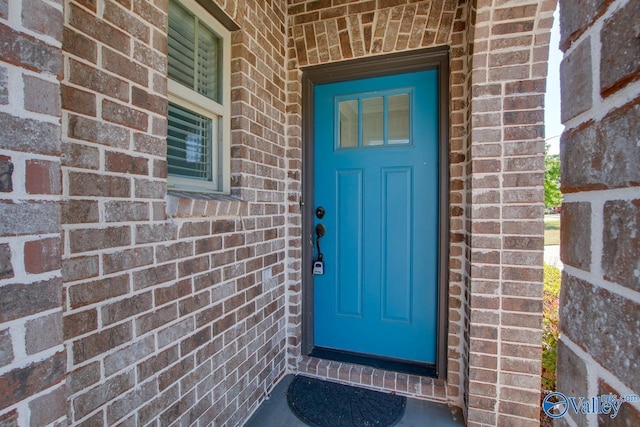 view of exterior entry with brick siding