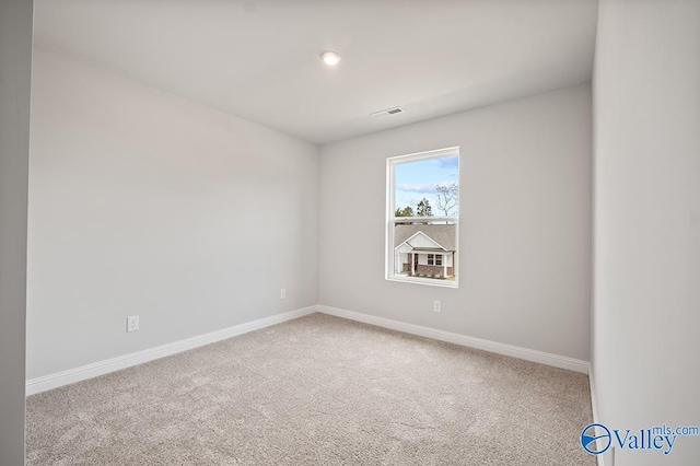 empty room featuring carpet floors, visible vents, and baseboards