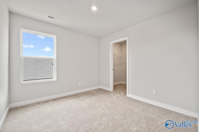 spare room featuring baseboards, visible vents, and carpet flooring