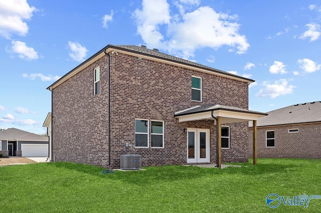 rear view of property with french doors, brick siding, a lawn, and central AC unit