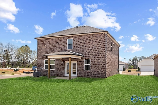 rear view of property featuring a garage, central AC unit, roof with shingles, a yard, and brick siding