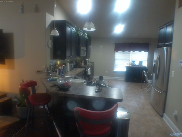 kitchen featuring blue cabinets, sink, hanging light fixtures, kitchen peninsula, and stainless steel appliances