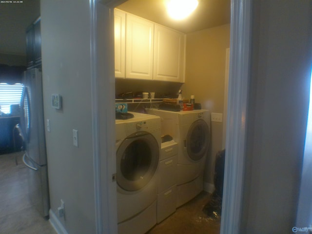 washroom with washer and dryer and cabinets