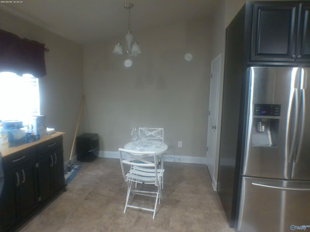 kitchen with pendant lighting, a notable chandelier, stainless steel refrigerator with ice dispenser, and light carpet