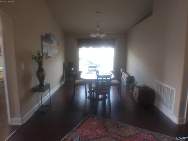 dining area featuring dark hardwood / wood-style flooring and a chandelier