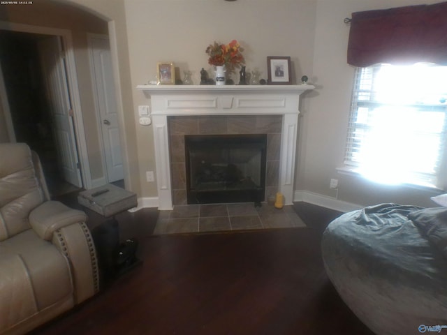 living room with hardwood / wood-style flooring and a tiled fireplace