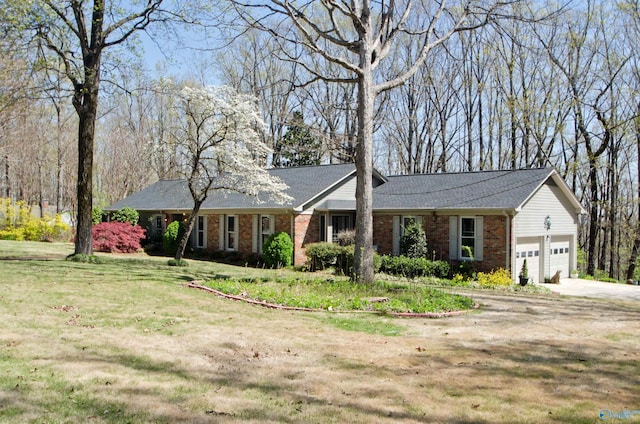 single story home featuring driveway, brick siding, a garage, and a front yard