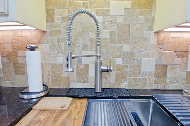 interior details with dark countertops and decorative backsplash