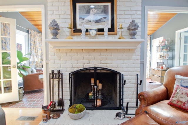 interior space with visible vents, wooden ceiling, and a brick fireplace