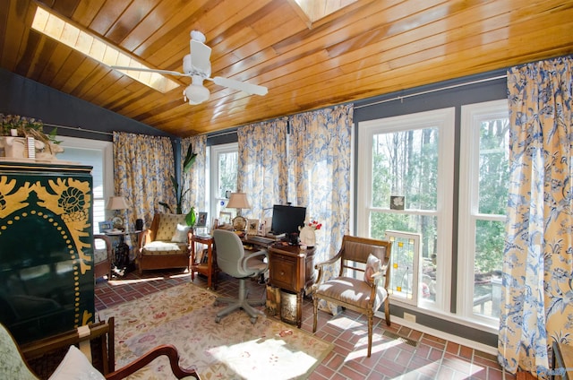 home office with wooden ceiling, a wealth of natural light, brick floor, and a ceiling fan