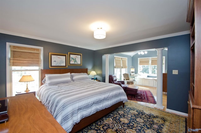 bedroom featuring ornamental molding, baseboards, and ornate columns