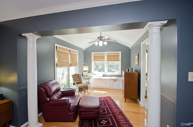 sitting room with decorative columns, a ceiling fan, ornamental molding, and light wood-style flooring