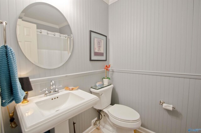 bathroom featuring crown molding, toilet, and a sink