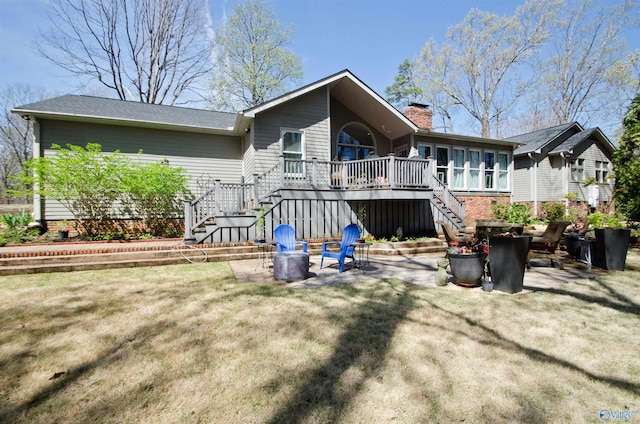 rear view of property featuring stairs, a patio area, a chimney, a deck, and a sunroom