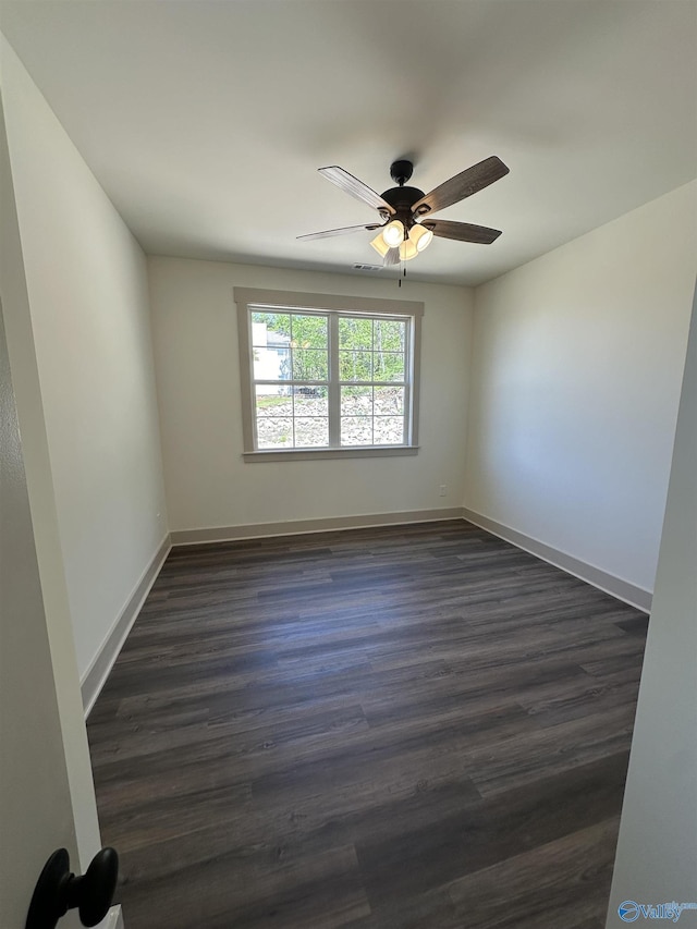 unfurnished room featuring dark wood-type flooring, baseboards, and a ceiling fan