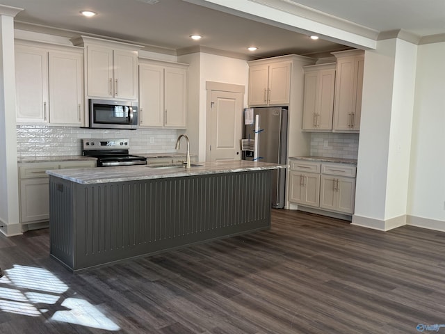 kitchen featuring light stone counters, dark wood-type flooring, a center island with sink, stainless steel appliances, and a sink