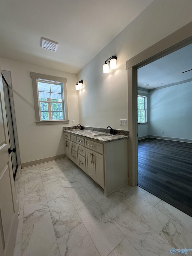 full bath with a sink, visible vents, baseboards, and marble finish floor
