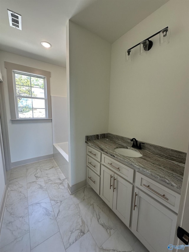 full bathroom featuring a bath, vanity, visible vents, marble finish floor, and baseboards