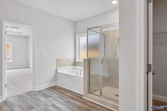 bathroom with hardwood / wood-style flooring, plus walk in shower, and plenty of natural light