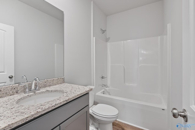 full bathroom with vanity, wood-type flooring, bathing tub / shower combination, and toilet