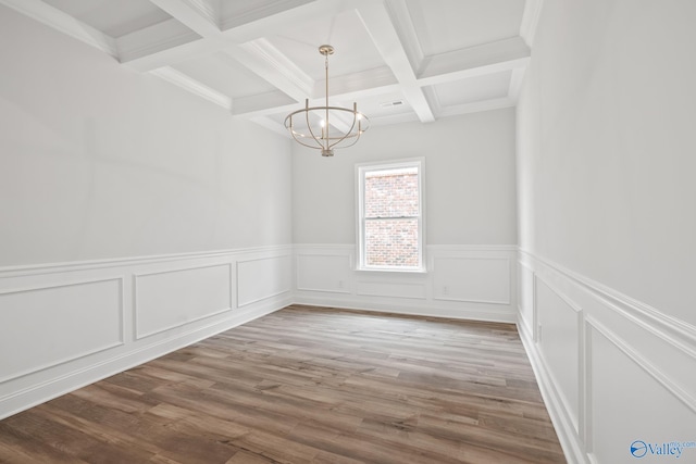 unfurnished room featuring coffered ceiling, wood-type flooring, beamed ceiling, and a chandelier