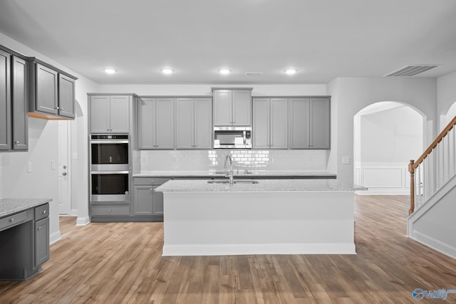 kitchen featuring appliances with stainless steel finishes, sink, light wood-type flooring, and gray cabinets