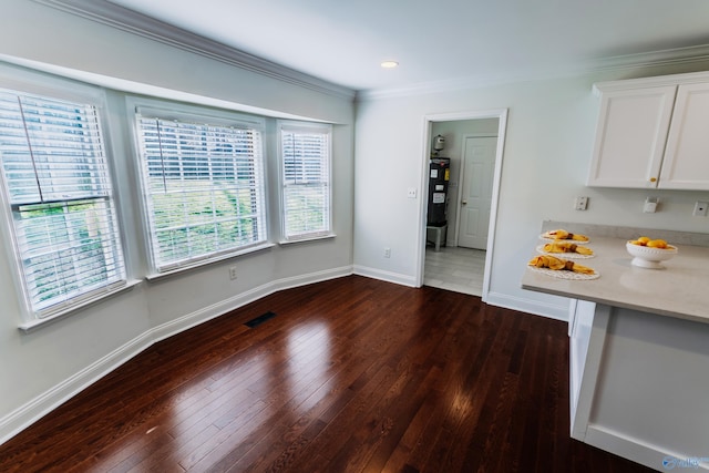 unfurnished dining area with ornamental molding and dark hardwood / wood-style flooring