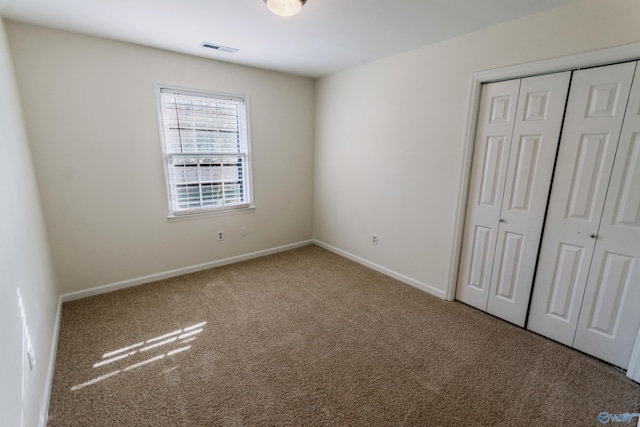 unfurnished bedroom with a closet and carpet flooring