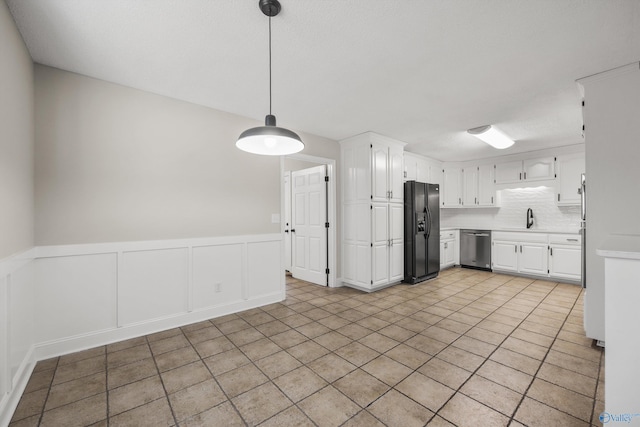 kitchen with white cabinets, black fridge with ice dispenser, stainless steel dishwasher, and pendant lighting