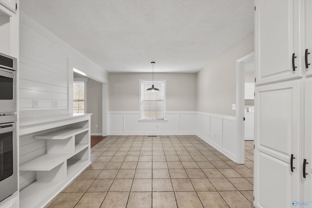 unfurnished dining area featuring light tile patterned floors and a textured ceiling